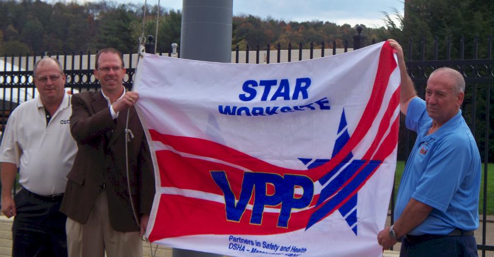 Management at the McWane Ductile Ohio facility display the newly-earned VPP flag in 2010.