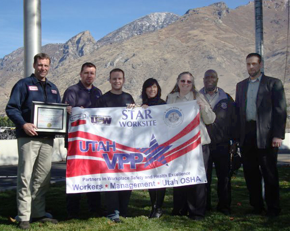Health & Safety team members at McWane Ductile's Utah facility display the newly-earned VPP Star Flag.